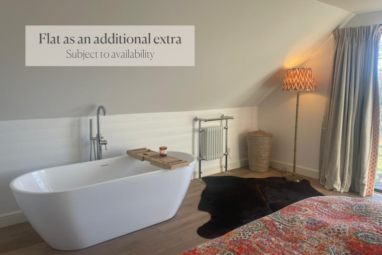 Contemporary bathroom with freestanding tub and cozy lighting.