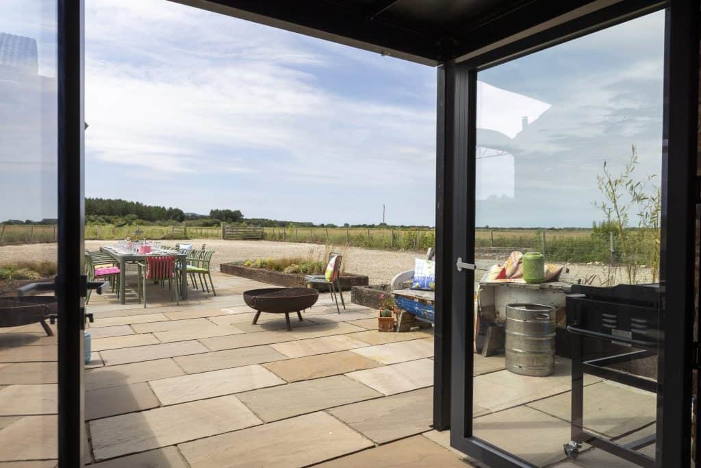Outdoor patio with seating and scenic countryside view at The Barn, Ganton.