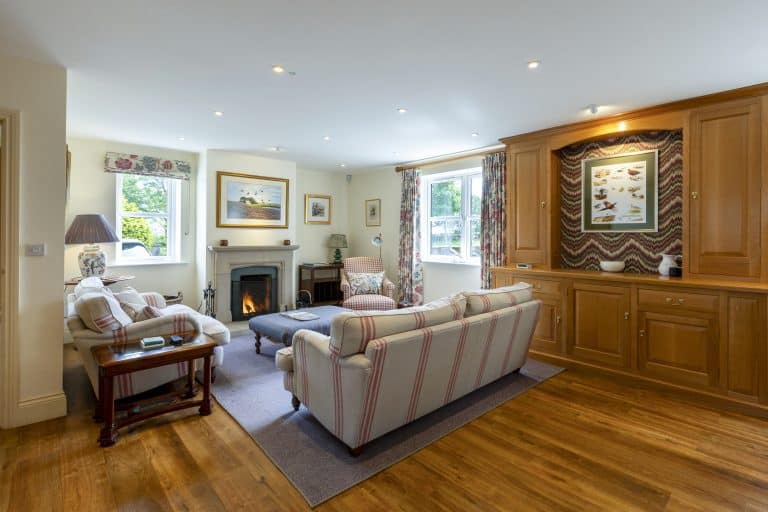 Cozy living room with sofas, fireplace, and wooden cabinet in Yorkshire cottage.