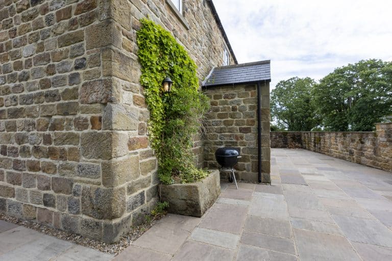 Stone wall with greenery and a barbecue on a terrace near Ripon.