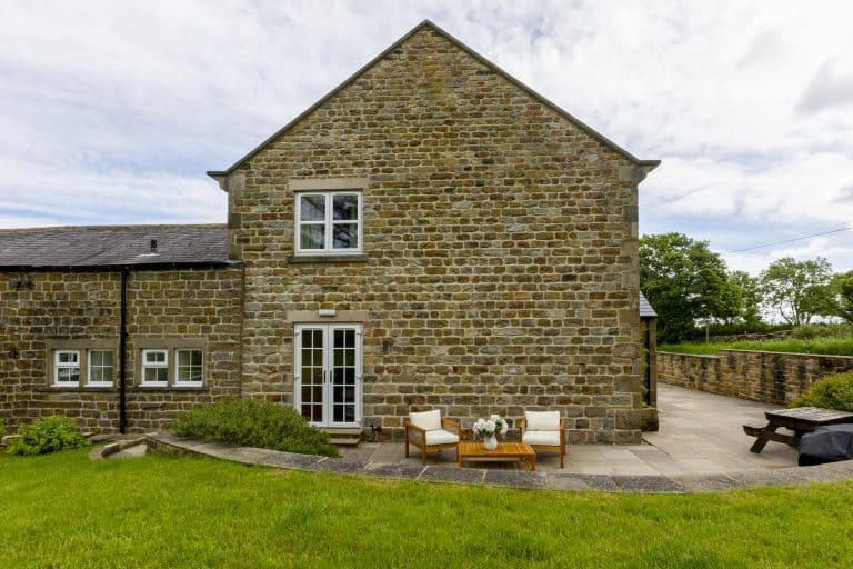 Stone cottage with outdoor seating and lush green lawn near Ripon.