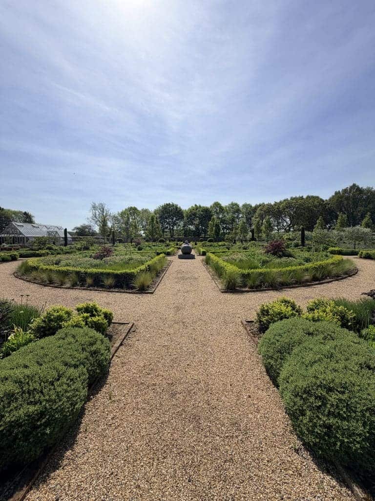 Symmetrical formal garden with trimmed hedges and gravel paths near York.