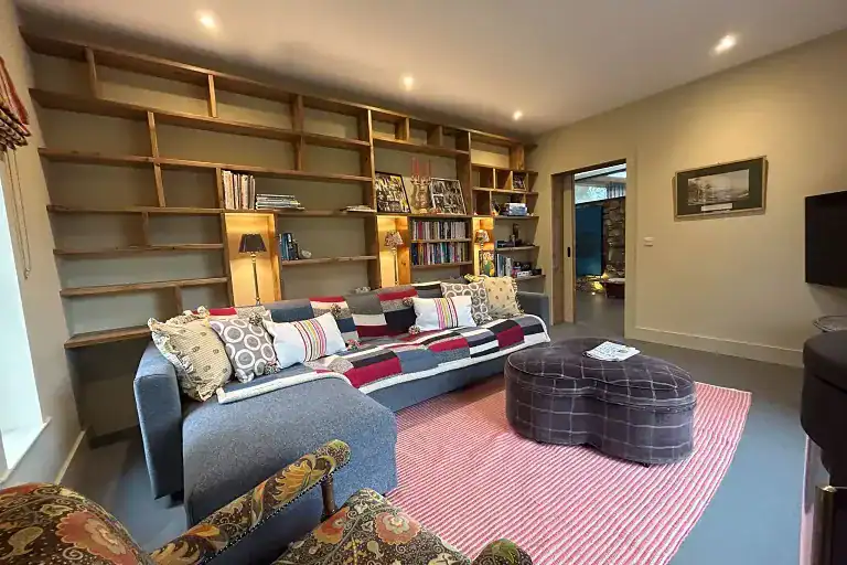 Contemporary living room with a large bookshelf and comfortable seating.
