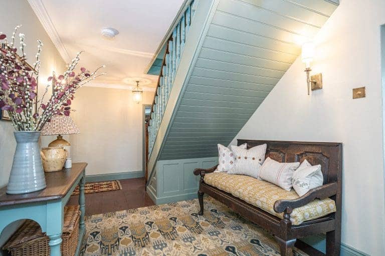 Cozy hallway with vintage sofa and staircase at The Vicarage, North York Moors.