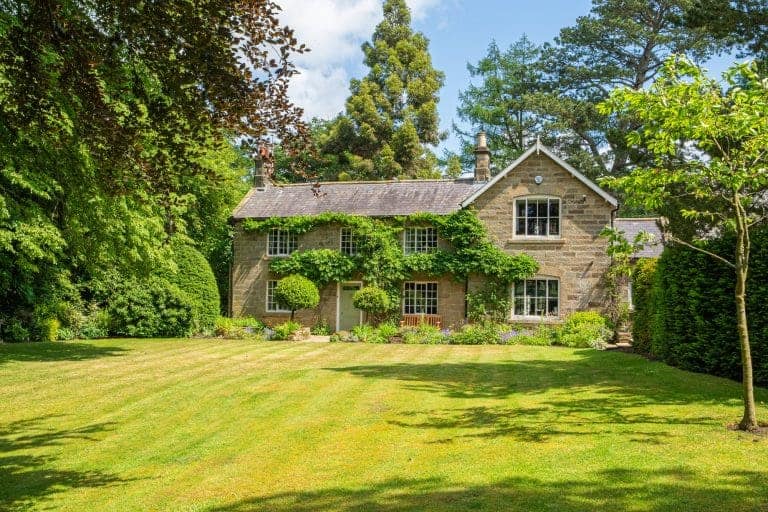 Traditional stone cottage surrounded by lush greenery in North York Moors.
