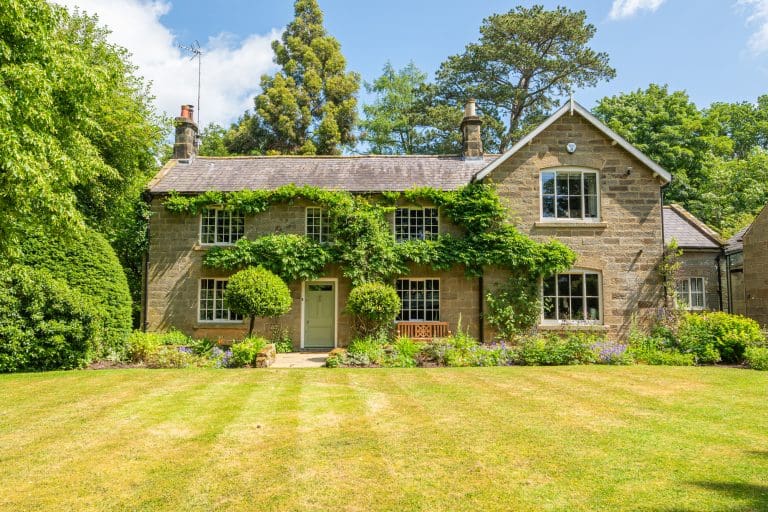 Historic stone cottage with lush garden and climbing plants in North York Moors.