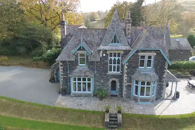 Historic stone house in Windermere with turrets and large windows.