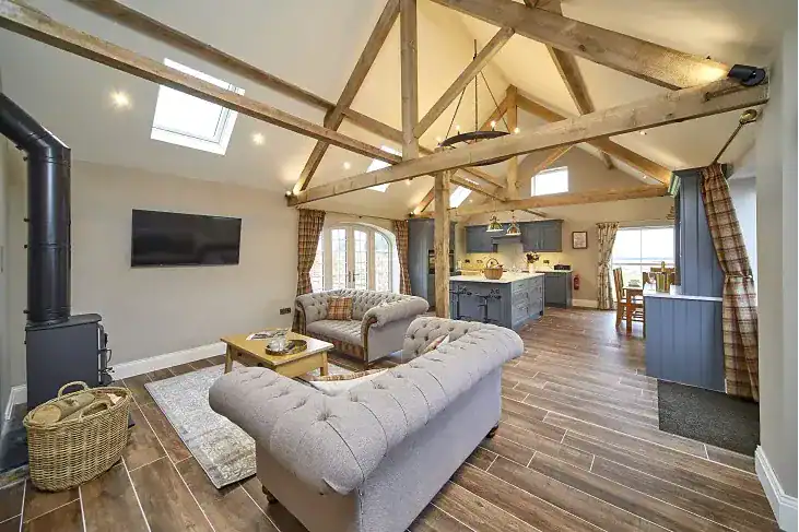 Spacious living area with exposed wooden beams and modern furnishings.