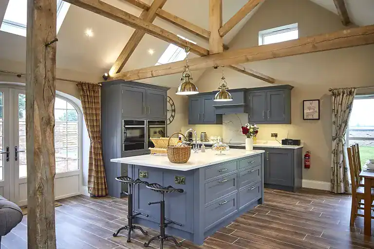 Stylish kitchen with blue cabinets and wooden beams in Yorkshire Escape.