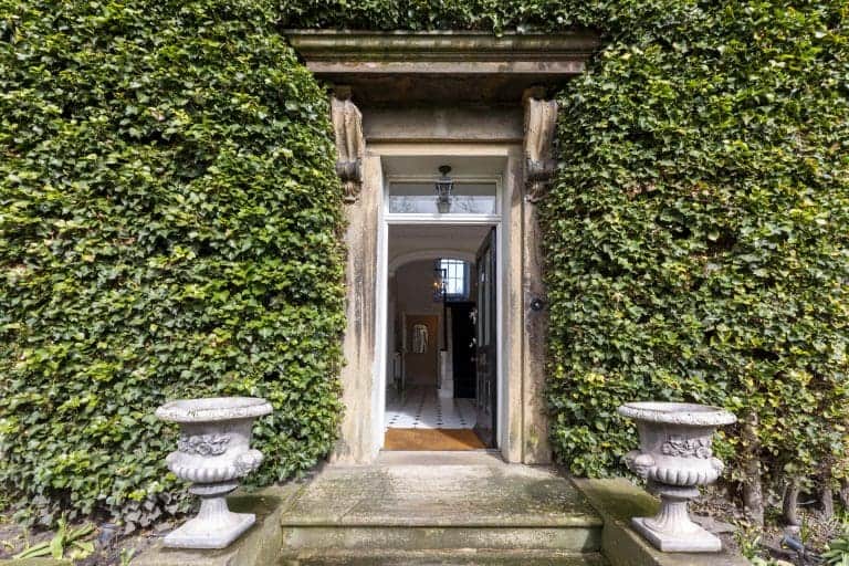 Historic entrance to Granby House in Harrogate with lush greenery and stone planters.