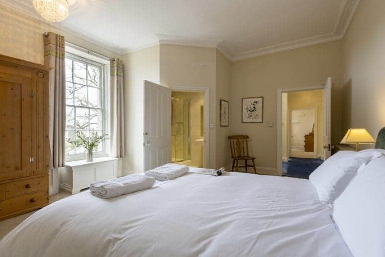 Cozy bedroom in Granby House, Harrogate with large window and classic decor.