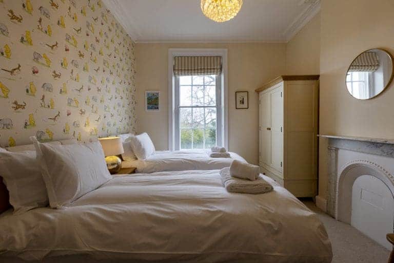 Cozy bedroom with two single beds and floral wallpaper in Harrogate.