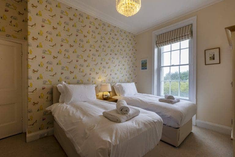 Cozy bedroom with twin beds and patterned wallpaper in Granby House, Harrogate.