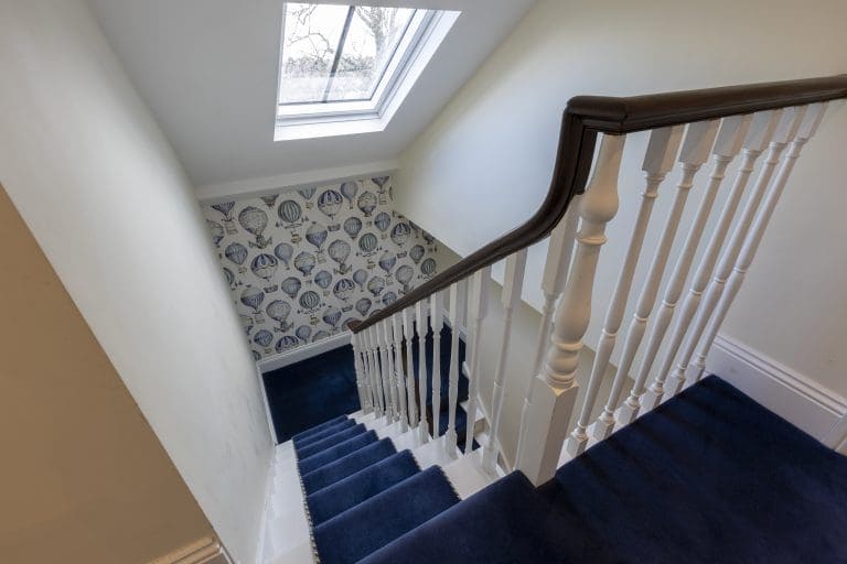 Interior view of staircase at Granby House, Harrogate with blue carpet and wallpaper.