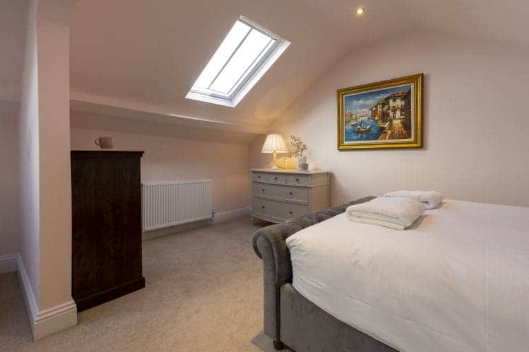Cozy bedroom in Granby House, Harrogate with skylight and elegant decor.