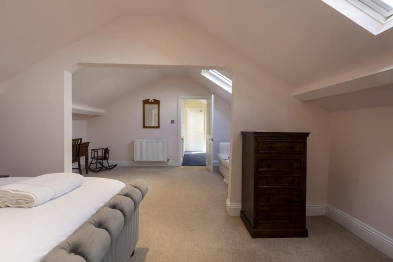 Spacious attic bedroom with sloped ceilings and skylights at Granby House, Harrogate.