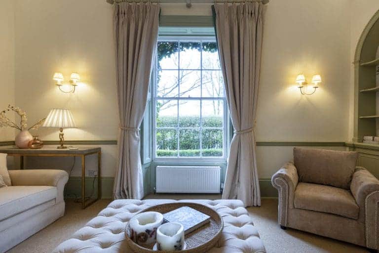 Elegant living room with large window, beige sofas, and soft lighting in Harrogate.