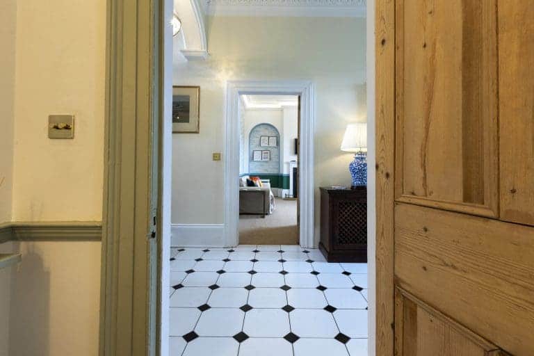 Interior view of Granby House, Harrogate, showing a hallway with black and white tiled floor.