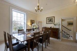 Elegant dining room in Granby House, Harrogate with wooden table and chandelier.