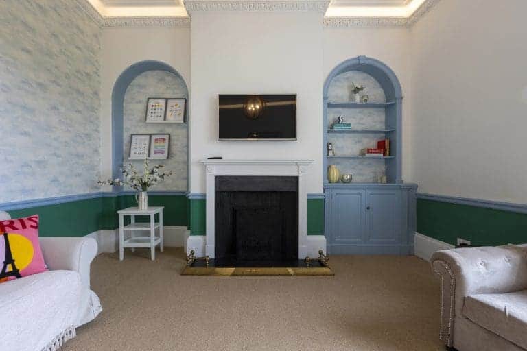 Elegant living room with fireplace and built-in blue shelves in Granby House, Harrogate.