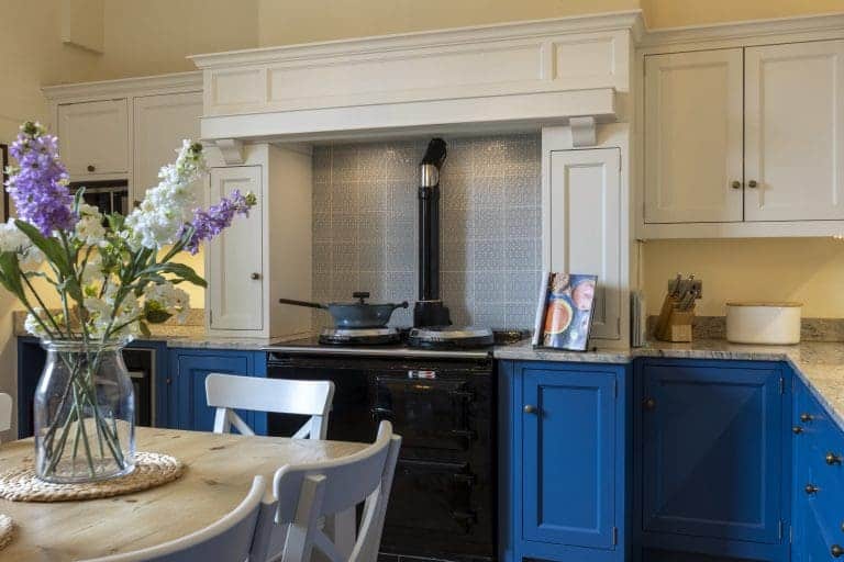 Modern kitchen with blue and white cabinets and a black stove.