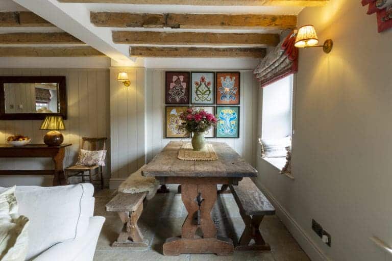 Cozy dining area with rustic wooden table and benches in Yorkshire cottage.