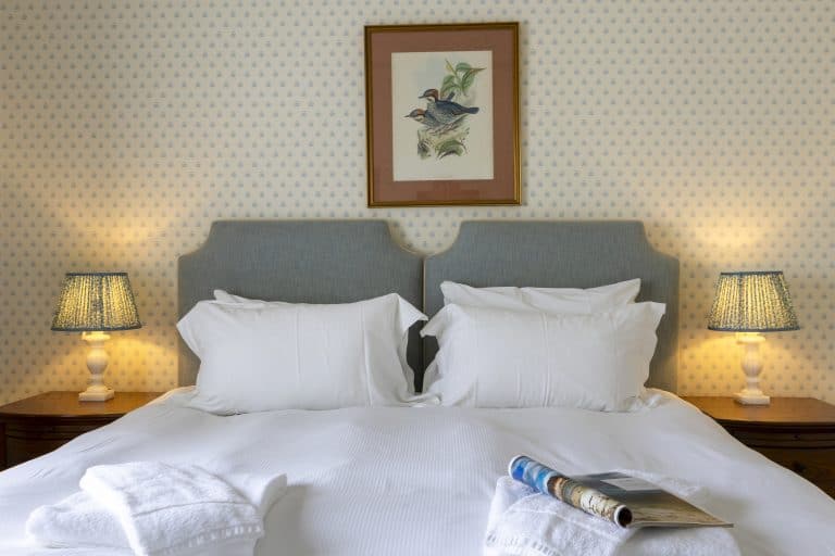 Comfortable bedroom with white bedding and bedside lamps in Yorkshire Dales.