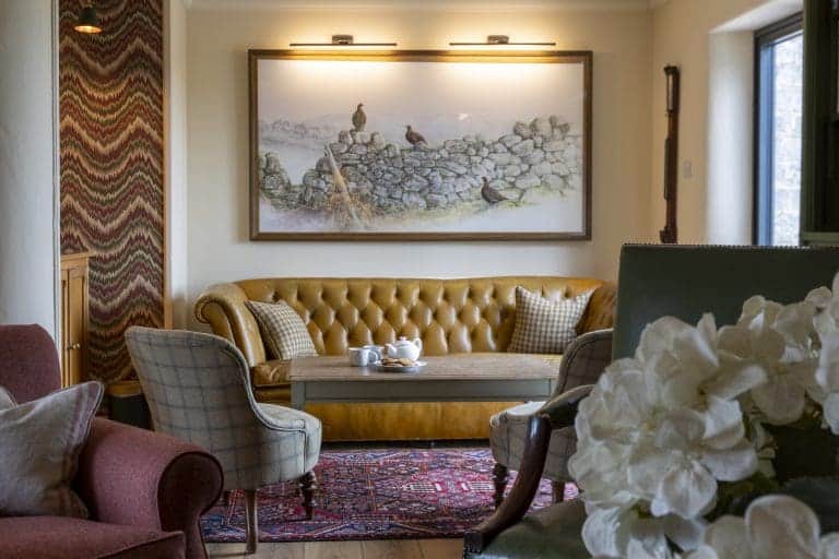 Cozy living room with vintage furniture and artwork in Yorkshire Dales cottage.