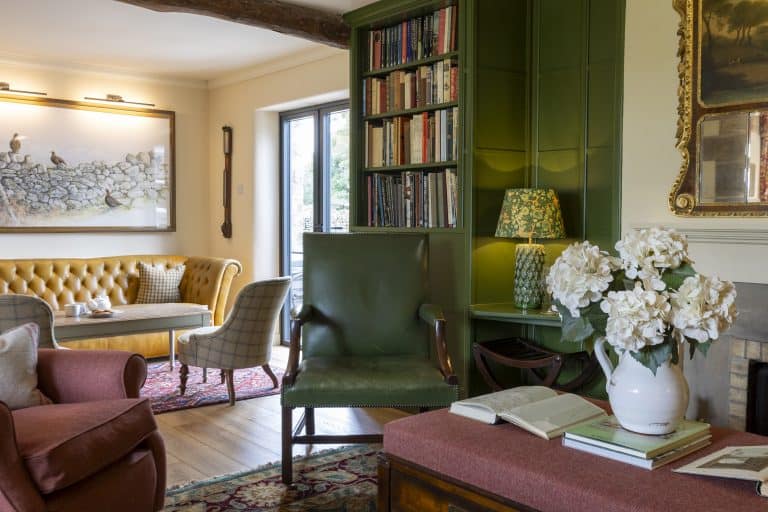 Elegant living room with green and yellow furniture and a bookshelf.