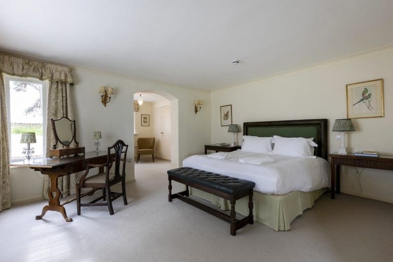 Elegant bedroom with a large bed, writing desk, and vintage decor in Yorkshire Dales.