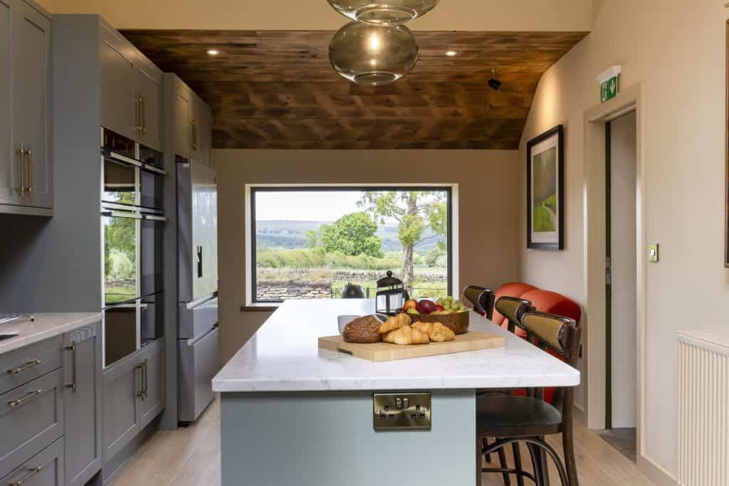 Modern kitchen with grey cabinets and a central island with breakfast items.