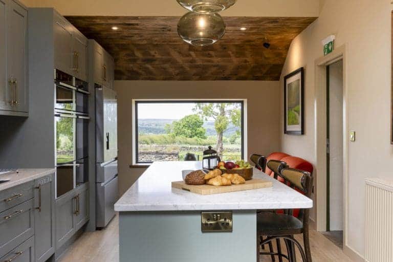 Modern kitchen with grey cabinets and a central island with breakfast items.