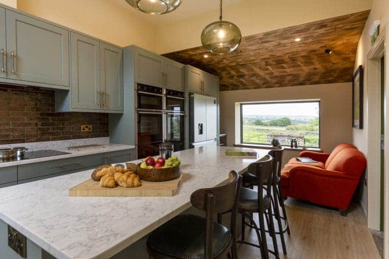 Modern kitchen with blue cabinets and marble island in Yorkshire Dales holiday home.
