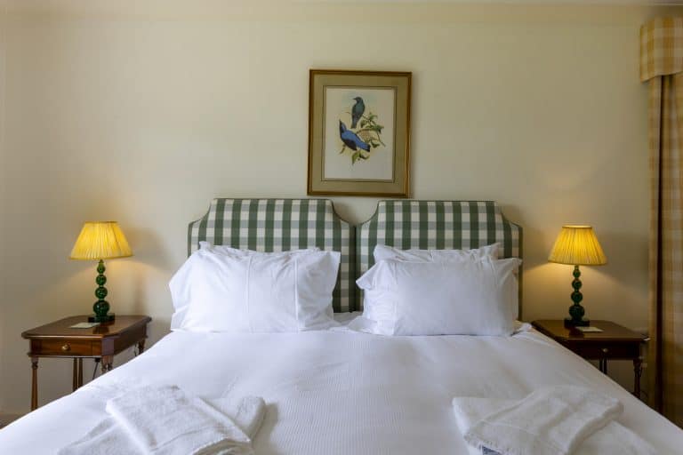 Comfortable bedroom with checkered headboard and bedside lamps in Yorkshire Dales.