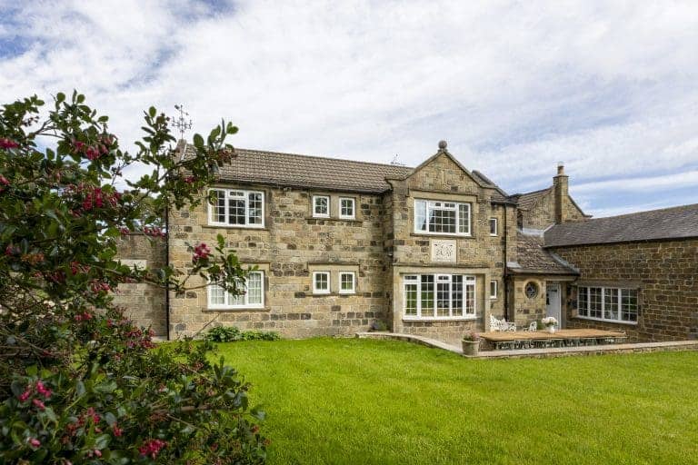 Traditional stone house in the Yorkshire Dales with a lush green lawn.