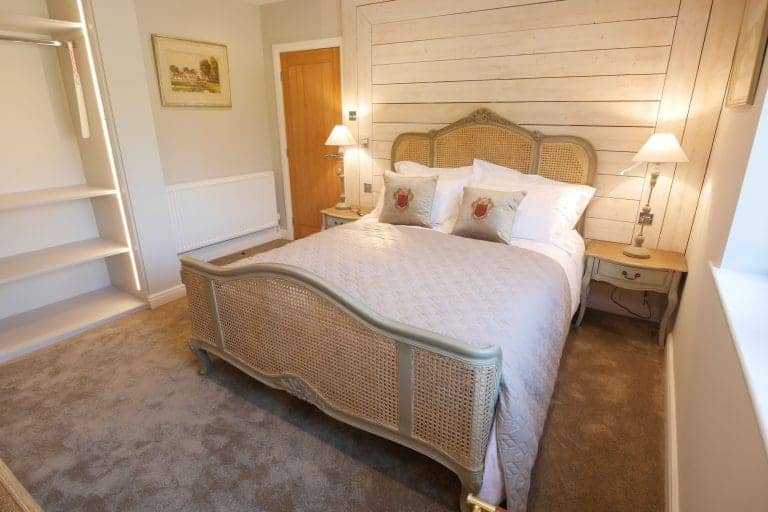 Comfortable bedroom with a large bed, bedside lamps, and rustic decor in East Yorkshire.