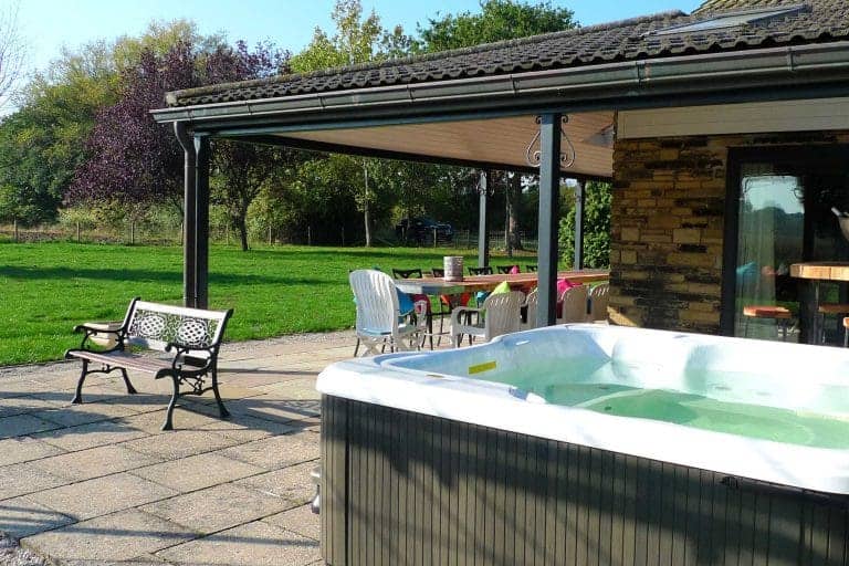 Outdoor hot tub at Cedar House in East Yorkshire with garden view.
