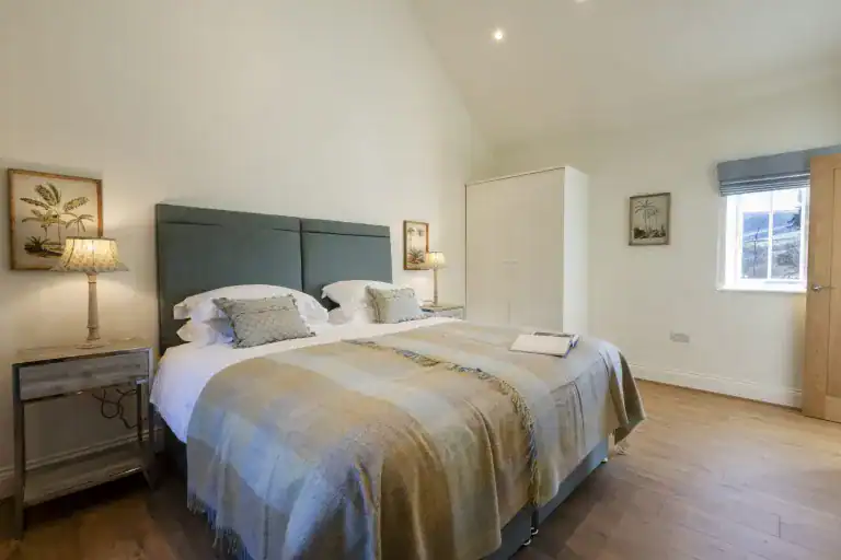 Cozy bedroom with a large bed, soft lighting, and wooden flooring in Yorkshire.
