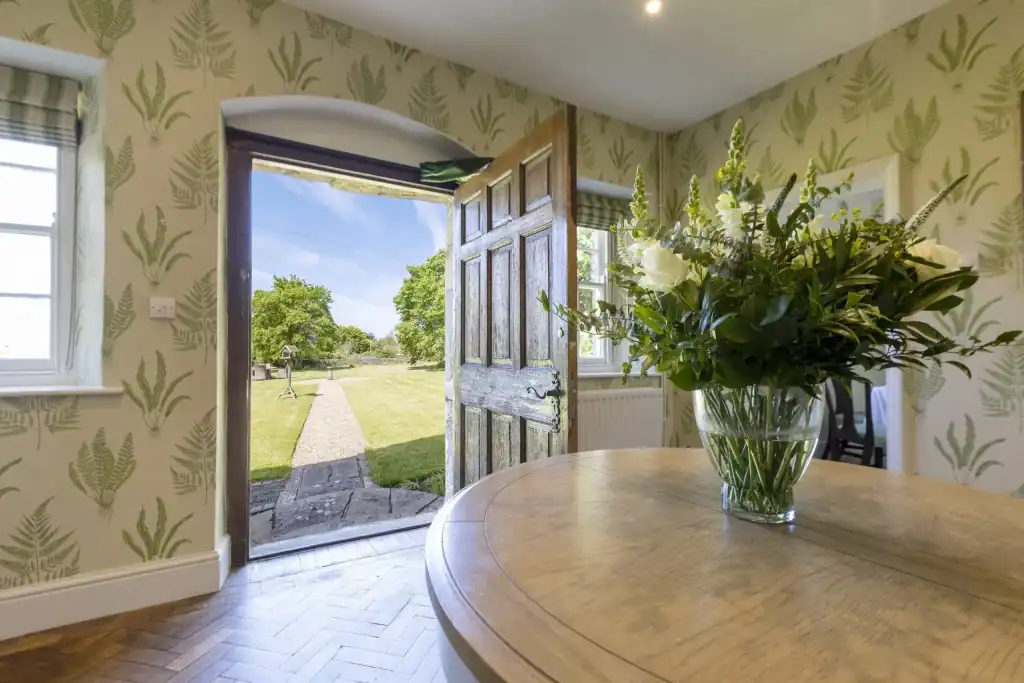 Charming Yorkshire cottage interior with open door to garden view.