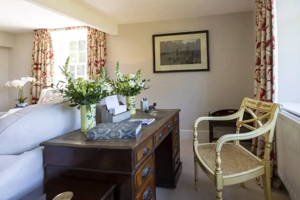 Cozy Yorkshire cottage living room with floral curtains and classic furniture.