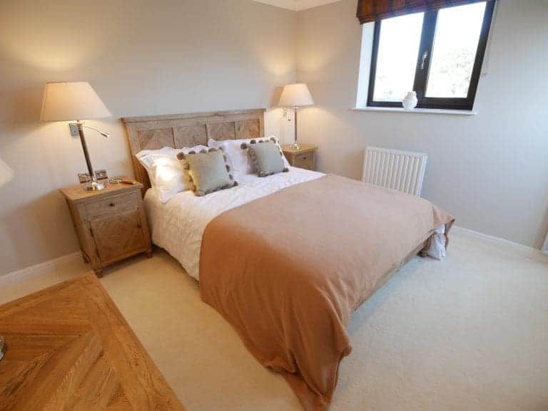 Cozy bedroom in Cedar House, East Yorkshire with wooden furniture and soft lighting.