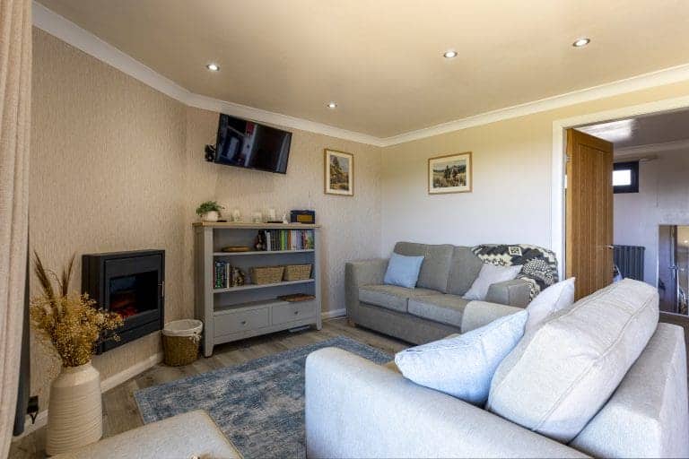 Comfortable living room with modern furnishings and a wall-mounted TV.