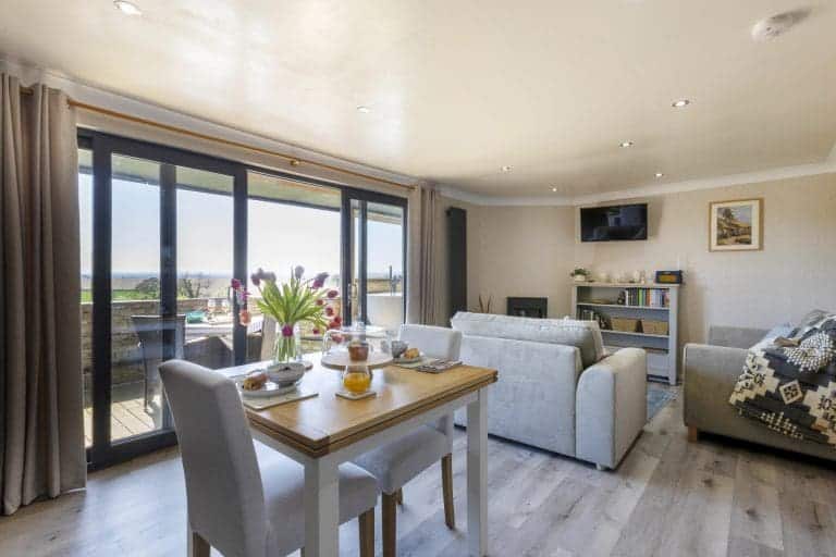 Modern living room with large glass doors and sea view in Yorkshire Escapes property.