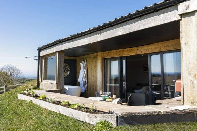 Modern outdoor terrace at Taras Sarn Lodge with scenic countryside views.