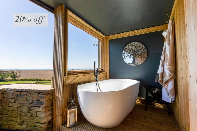 Modern freestanding bathtub with scenic countryside view in Yorkshire escape.