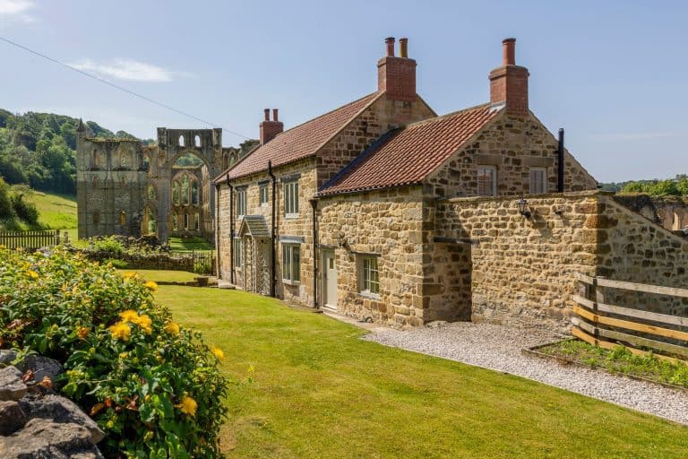 Historic stone cottage with red tiled roof and surrounding garden in Yorkshire.
