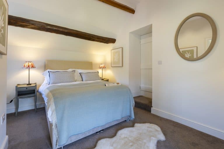 Cozy bedroom at Abbey Cottage near Helmsley with rustic beams and modern decor.