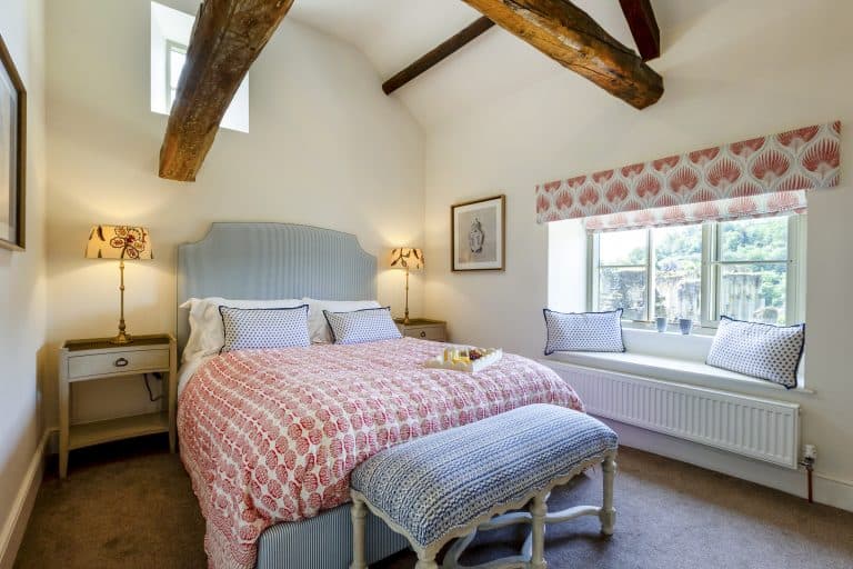 Cozy bedroom at Abbey Cottage with exposed wooden beams and soft natural light.