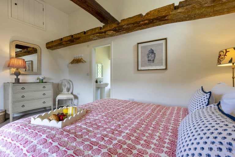 Cozy bedroom at Abbey Cottage with exposed wooden beams and charming decor.