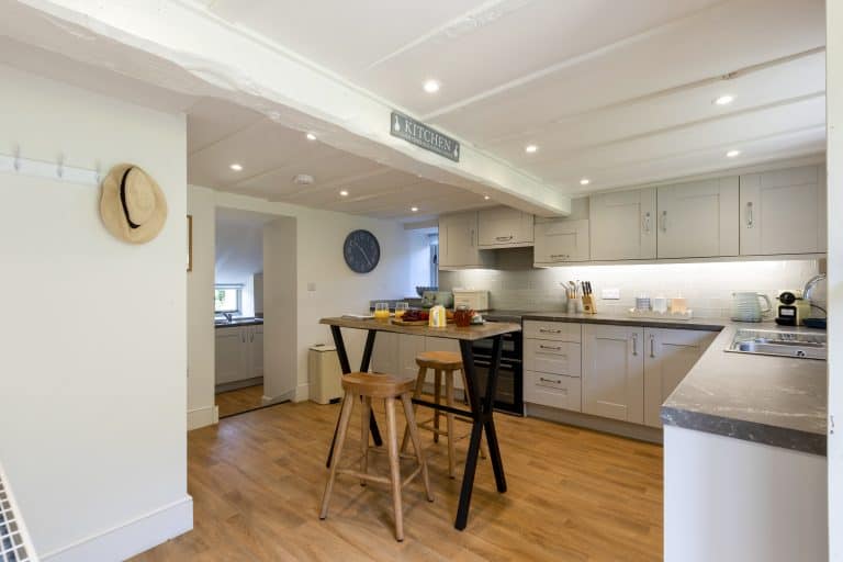 Modern kitchen with grey cabinets and wooden flooring at Abbey Cottage.